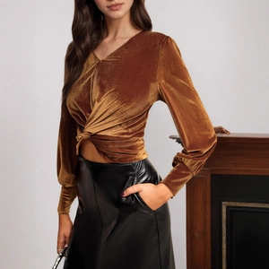 Detail of velvet top featuring a chic waist twist design and rich metallic sheen