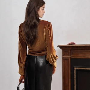 Detail of elegant twisted velvet long sleeve top with sleek black leather pencil skirt