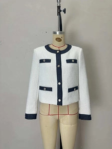 Elegante giacca in tweed bianco con finiture in denim a contrasto e bottoni dorati su manichino