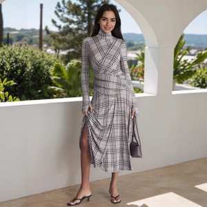 Detail view of the high-slit design and waist pleats on this plaid long-sleeve dress