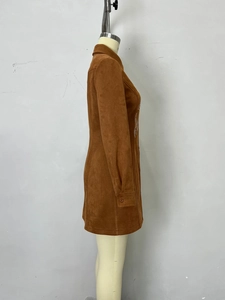 Side view of a brown suede dress with lapel collar and white side embroidery detail