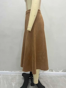 Detailed view of camel suede midi skirt showing A-line silhouette and fabric texture