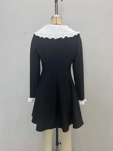 Robe trapèze noire élégante avec col claudine blanc et poignets à volants, vue de dos