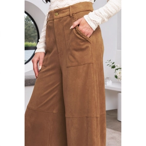 Detail der braunen Wildlederhose mit hoher Taille, Metallknopf und geflochtener Tasche