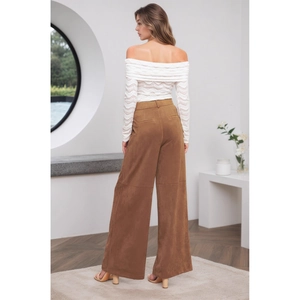 Detail der braunen Wildlederhose mit hohem Bund und elegantem weißem Spitzenoberteil