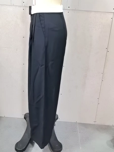 Detail view of high waist black straight leg trousers with elegant side pleats