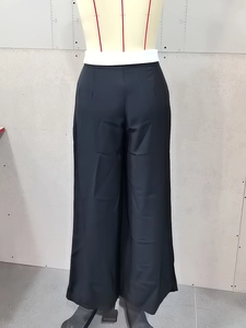 Detail of high waisted black wide leg trousers with premium drape and elegant tailoring