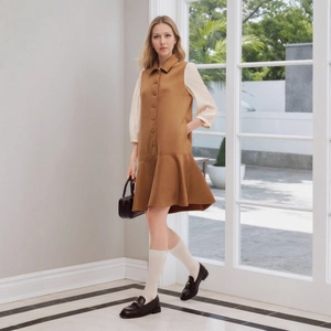 Detail of elegant two-tone dress with button decor, tiered hem, and three-quarter sleeves