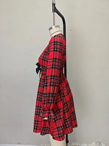 Détail de la robe de Noël à carreaux rouges montrant la taille élastique et le nœud