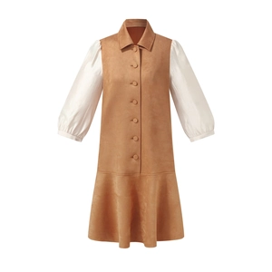 Detail of suede patchwork dress showing brown bodice, white puff sleeves, and tiered hem