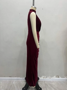 Detail view of burgundy velvet evening gown showing the high collar and pleated fabric drape