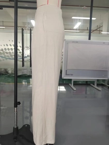Detail view of high-waisted wide leg cotton pants in beige showing side pockets and texture