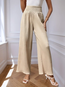 Détail du pantalon large plissé doré champagne à taille haute et ceinture élastique