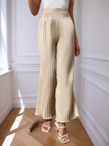 Détail de la taille haute élastiquée sur le pantalon large en mousseline plissée beige