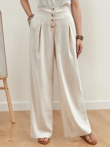 Detail of high waisted wide leg cotton linen trousers with button fly and woven texture