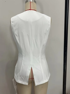 Detail view of white sleeveless vest back featuring center seam and small hem slit detail