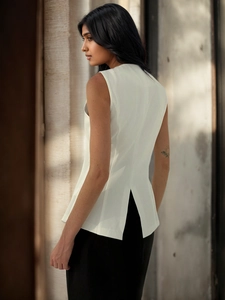 Detail view of white V-neck vest showing structured fabric and stylish back slit design