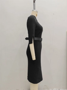 Detail of elegant black sheath dress featuring split cuffs and a matching leather belt