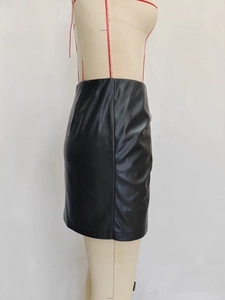 Detail of high-waist black PU leather A-line mini skirt with rivet accents and smooth texture
