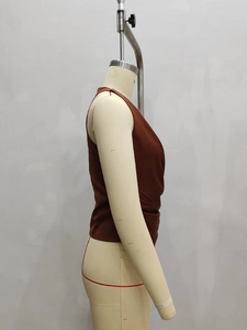 Detail view of the side pleats and silky satin texture on a dark brown halter neck top