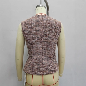 Gros plan d'un gilet en tweed multicolore avec ceinture étroite et texture tissée