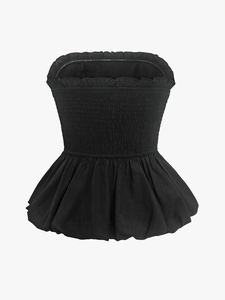 Détail du dos smocké élastique et de l'ourlet à volants sur un haut noir à épaules nues