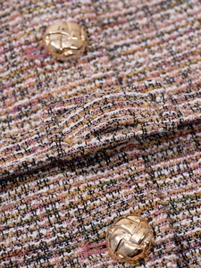 Gros plan sur un tissu en tweed multicolore avec texture tissée et boucle en métal doré