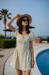 Robe à fleurs avec manches bouffantes et décolleté en U dans un décor de plage idyllique