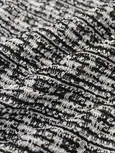 Detailed macro view of black and white French retro tweed fabric texture for dress