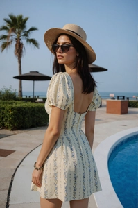 Détail de robe fleurie avec manches bouffantes, col carré et dos ouvert élégant