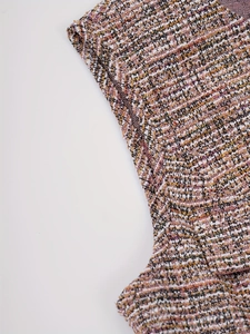 Vue détaillée de la texture du tissu en tweed multicolore avec des accents de fils dorés