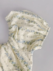 Détail de manches bouffantes à fleurs avec tissu élastique froncé et motifs bleus