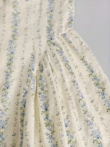 Détail du tissu seersucker fleuri avec fleurs bleues et coutures plissées fines