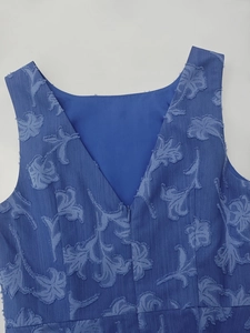 Detailansicht aus tiefblauem Jacquard-Stoff mit floralen Texturen und V-Ausschnitt Reißverschluss