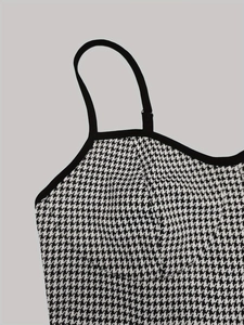 Detail of classic black and white houndstooth knit jumpsuit with delicate shoulder straps