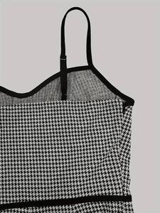 Detail of houndstooth camisole featuring black adjustable straps and side zipper hardware