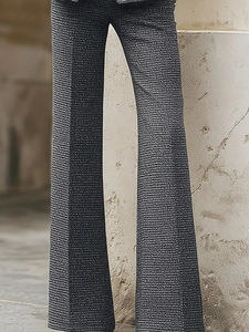Detail view of high-waist flared pants in charcoal grey plaid fabric with fine texture