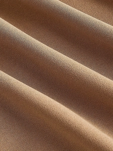 Macro shot of coffee brown textured crepe fabric showing fine grain and soft drape