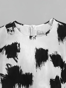 Detail of round neckline and back invisible zipper on black and white abstract print dress