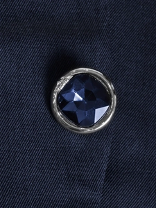 Detail showing high-end dark blue faceted gemstone button on a slim fit office blazer