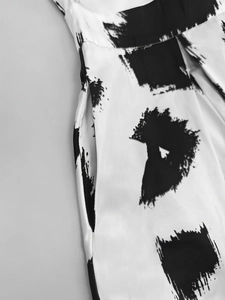 Detailed macro view of invisible side pocket and abstract black and white print on dress