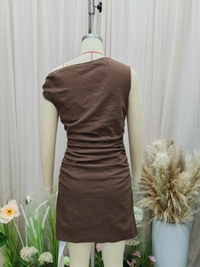 Brown sleeveless ruched mini dress with asymmetric neckline on display mannequin