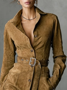 Détail de robe en daim marron avec col à revers, boutons et ceinture à boucle métallique argentée