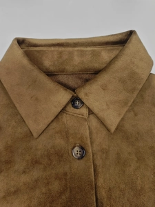 Vue macro du col en suédine marron et des boutons en écaille de tortue de la robe vintage