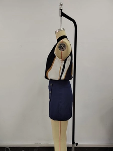 Detail view of sleeveless geometric color-block top and navy shorts with side buttons