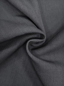 Macro shot of dark grey ribbed fabric detail showing premium texture and drape