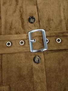 Détail de la taille d'une robe en daim marron avec boucle argentée et boutons écailles