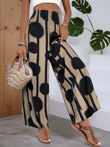 Detail of high-waisted bohemian wide-leg trousers with polka dot and stripe prints