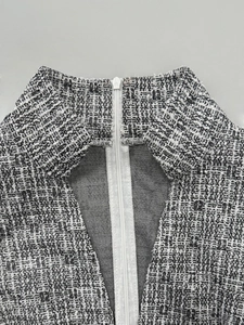 Detail view of V-neck tweed fabric dress with premium SBS zipper on woven texture