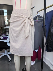 Minimalist beige wrap midi skirt with side bow tie, shown on a mannequin